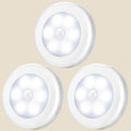 Three round white NovaPulse infrared motion-sensor lights for cupboards and wardrobes