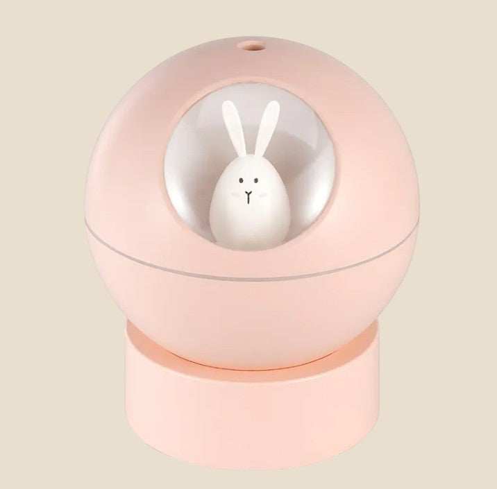Nawilżacz powietrza NovaPulse BunnyMist w kształcie różowej kuli z uroczym białym królikiem wewnątrz