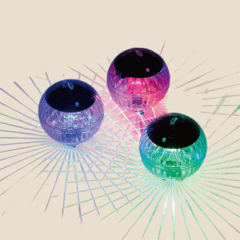 Three NovaPulse NovaSphere solar garden globes casting coloured light across water