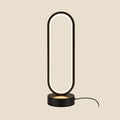 NovaPulse OvalAura table lamp with an oval LED ring in matt black, emitting warm light