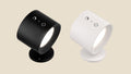 Two NovaPulse PivotRGB wireless wall spotlights in black and white with 360-degree rotation