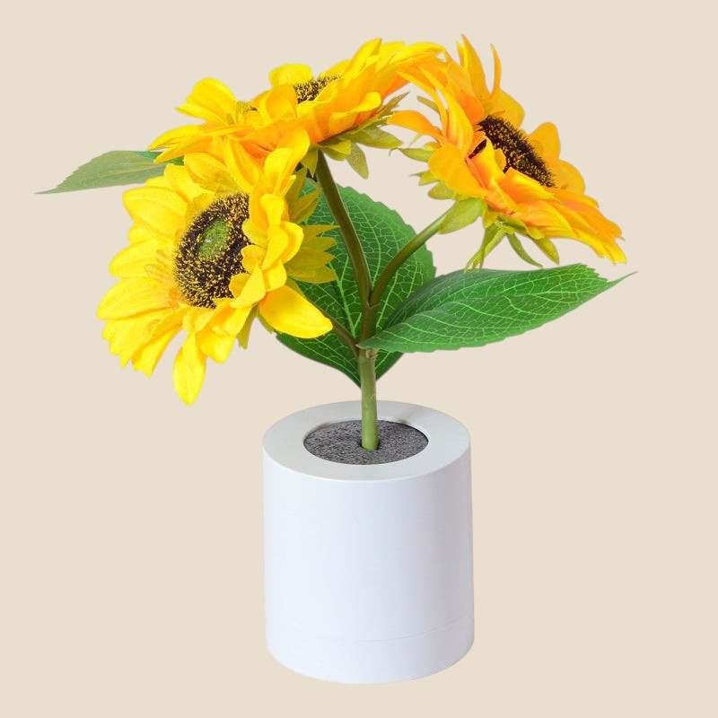 Lampa nocna NovaPulse SunGlow w kształcie słonecznika z trzema kwiatami w białej podstawie, ładowana przez USB.