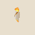 NovaPulse TwistAura wall light with a twisted shape, black casing and gold interior emitting warm light
